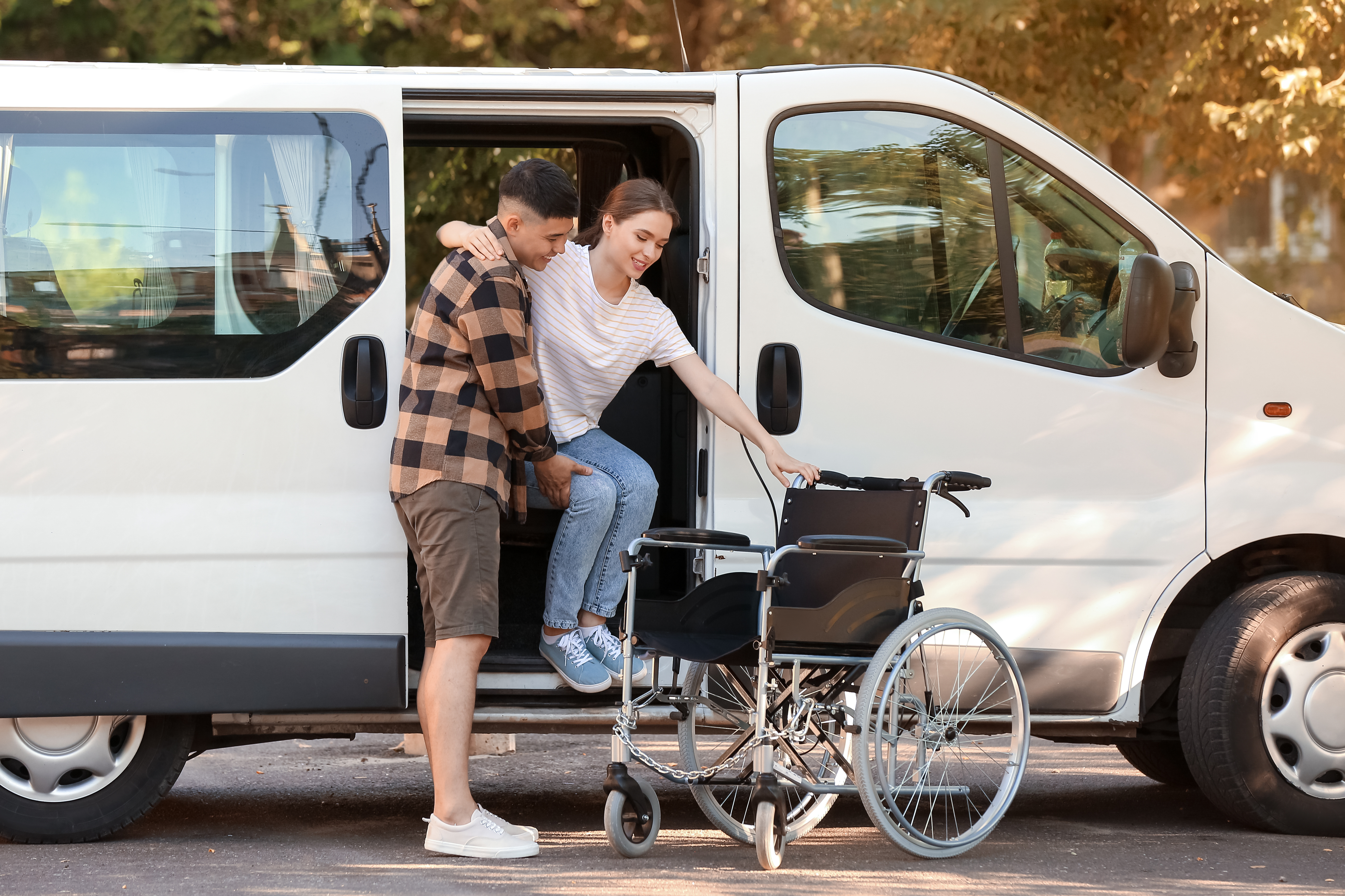 Man helping his handicapped wife to get out of van