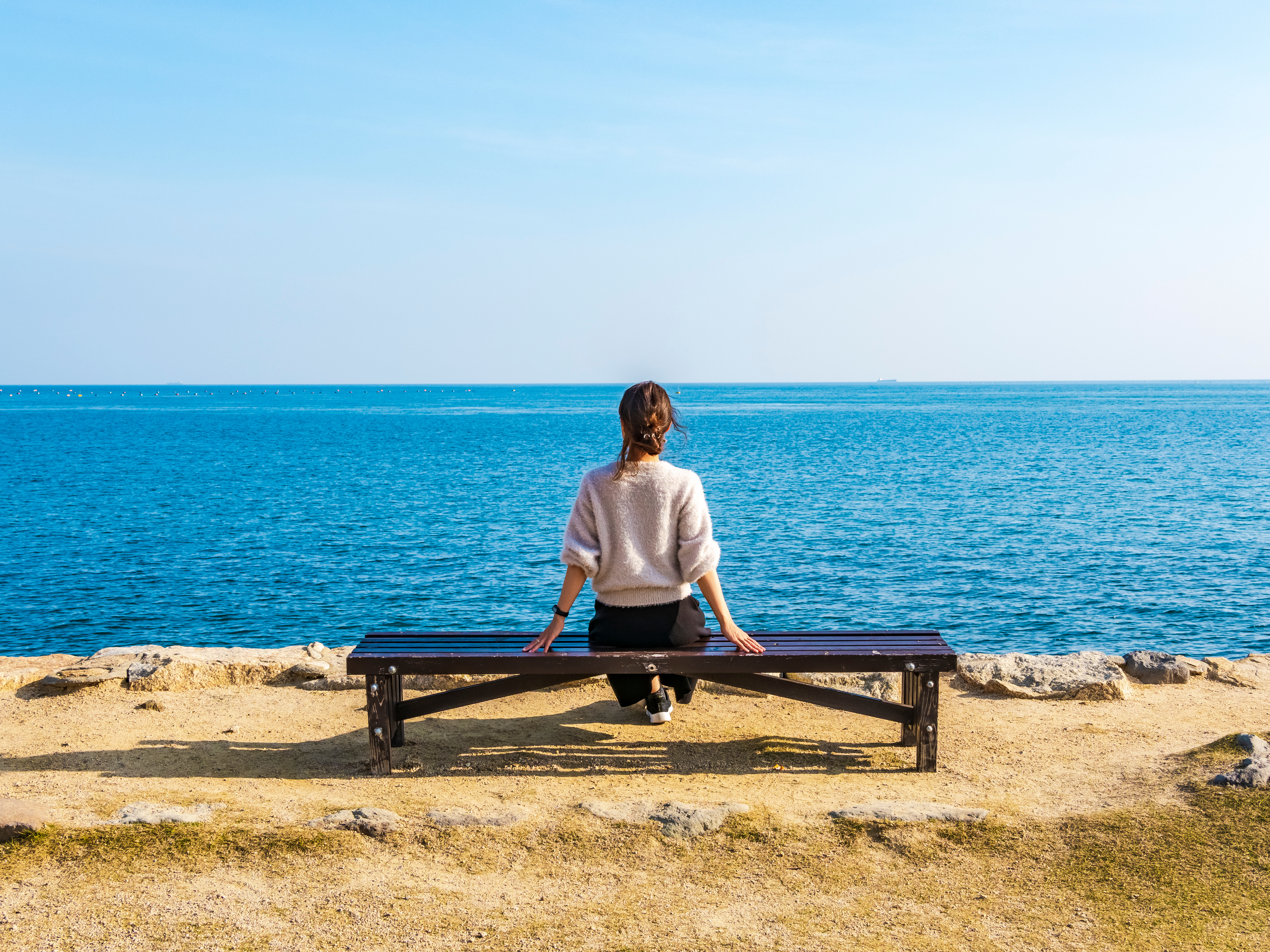 ベンチに座る女性の後ろ姿